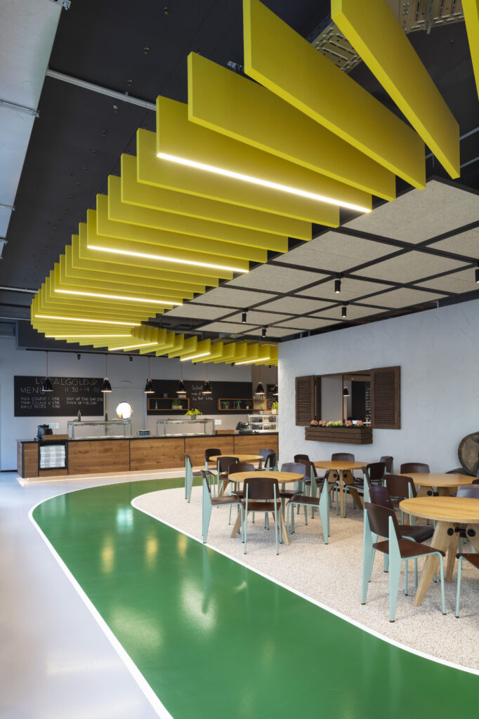 Mensa, Restaurant innen gelben Deckenlamellen mit grünem Linoleum