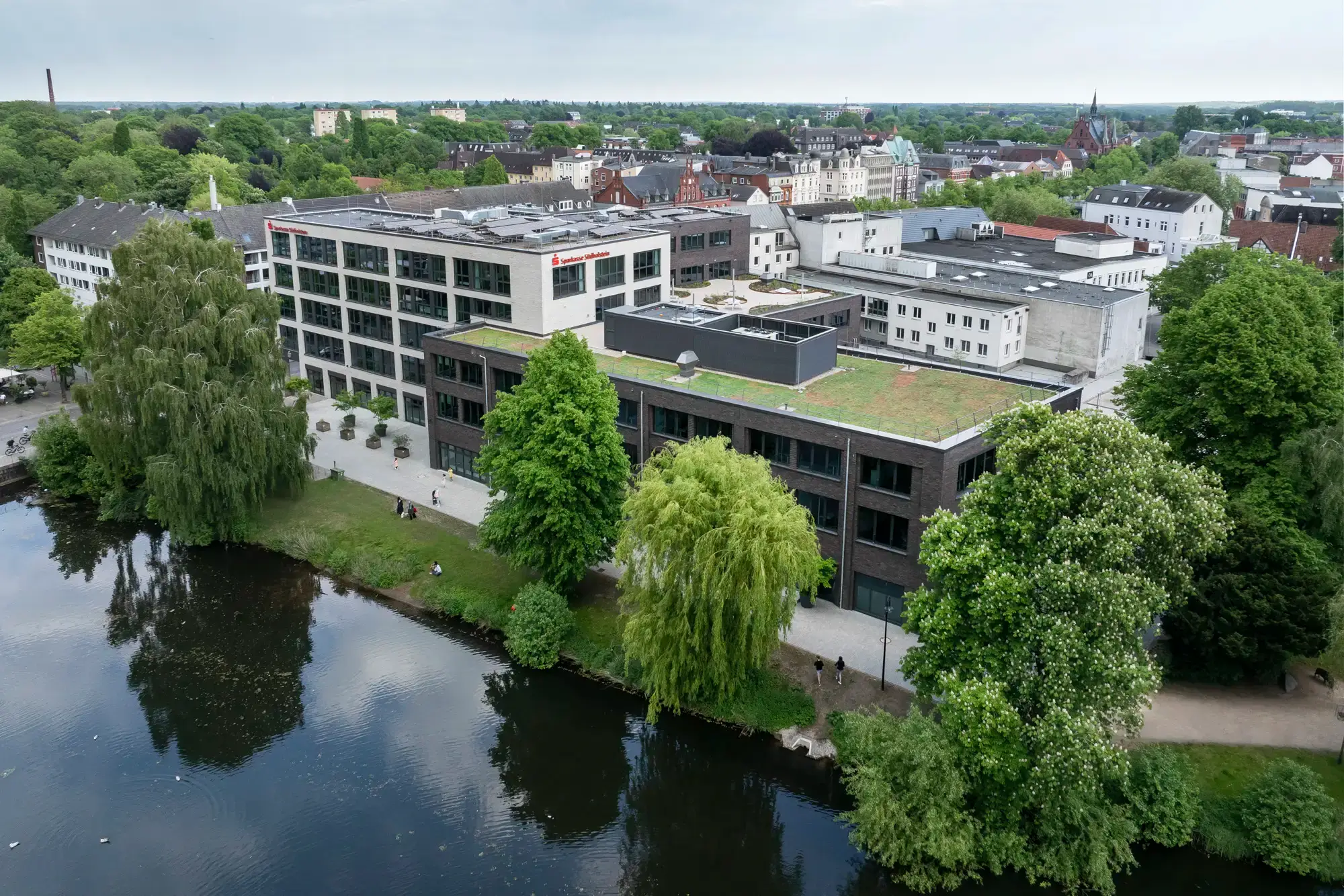 Bürogebäude aus der Luft mit See im Vordergrund